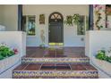 Charming front porch featuring Spanish tile steps with decorative tiles, planters, and a black door with brass trim at 1175 Jackson Rd, Clearwater, FL 33755