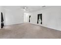 Bright living room featuring neutral carpeting, white walls, and natural light at 12430 Oconee Blvd, New Port Richey, FL 34654