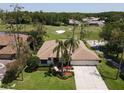 Golf course home showcasing lush landscaping and mature trees surrounding a paver driveway and neutral exterior at 1311 Fallsmeade Ct, Oldsmar, FL 34677
