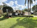 Well-manicured lawn and shrubbery surround this home with neutral exterior at 1311 Fallsmeade Ct, Oldsmar, FL 34677