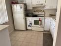 Features bright kitchen appliances and neutral tiled floors at 1370 Heather Ridge Blvd # 310, Dunedin, FL 34698