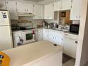 Bright kitchen features white cabinets, appliances, and a functional layout at 1370 Heather Ridge Blvd # 310, Dunedin, FL 34698