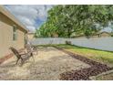 Serene backyard featuring a pebble-covered area with seating and a spacious, well-maintained lawn at 1418 Rushgrove Cir, Dover, FL 33527