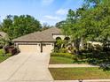 Charming beige house with a three-car garage and lush landscaping enhancing its curb appeal at 15254 Bellamy Rd, Tampa, FL 33625