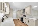 Bright kitchen features updated cabinets, countertops, modern appliances, and stylish hardwood floors at 208 Ne Lincoln N Cir, St Petersburg, FL 33702