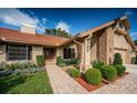 Beautiful one-story home featuring a brick pathway, lush landscaping, and a well-maintained facade at 2392 Hillcreek E Cir, Clearwater, FL 33759