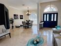 Formal dining and front entry area featuring neutral paint, a large chandelier, and plenty of natural light at 2679 Saddlewood Ln, Palm Harbor, FL 34685