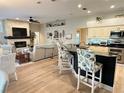 Open-concept kitchen and living area featuring a stone fireplace, breakfast bar, and wood floors at 2679 Saddlewood Ln, Palm Harbor, FL 34685