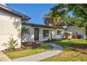 The well-maintained yard leads to the front of this attractive, single-story residence at 321 Shore E Dr, Oldsmar, FL 34677