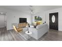 Bright living room featuring a modern ceiling fan, stylish furniture, and large window at 321 Shore E Dr, Oldsmar, FL 34677