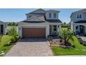 Charming two-story home with a well-kept lawn and brick paved driveway at 34135 White Fountain Ct, Wesley Chapel, FL 33545