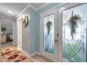 Bright entryway featuring decorative glass doors, and a view of a nicely decorated interior at 3957 Tarpon Pointe Cir, Palm Harbor, FL 34684