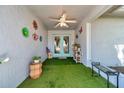 Cozy front porch with artificial grass flooring, creating a welcoming and decorative entryway at 3957 Tarpon Pointe Cir, Palm Harbor, FL 34684