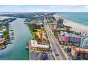 An aerial shot displays the yellow condo near the water and features a picturesque coastal view at 4103 Gulf Blvd # 106, St Pete Beach, FL 33706