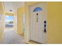 A close-up of the white front door of the residence, with a secure entry system at 4103 Gulf Blvd # 106, St Pete Beach, FL 33706