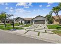 Beautiful single-story home featuring stone accents, manicured landscaping, and a modern driveway with grass details at 4204 Saltwater Blvd, Tampa, FL 33615