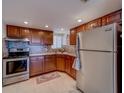 Functional kitchen features classic wood cabinetry, stainless steel appliances, tile backsplash, and plenty of storage at 500 N Osceola Ave # 609, Clearwater, FL 33755