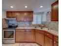 Traditional-style kitchen features wood cabinets, neutral countertops, stainless steel appliances, and tiled backsplash at 500 N Osceola Ave # 609, Clearwater, FL 33755
