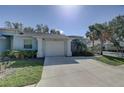 Inviting single-story home with a spacious driveway, attached garage, and lush tropical landscaping at 5104 2Nd E Ave, Palmetto, FL 34221