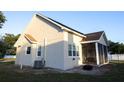 Back exterior showcasing the home's structure, including a screened-in porch and tidy landscaping, great for relaxing in comfort at 601 Gay Rd, Seffner, FL 33584