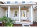 Inviting front porch with white columns, rocking chairs, and a decorative glass front door at 601 Gay Rd, Seffner, FL 33584