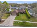 Aerial view of a charming single-story brick home with a lush green lawn and well-maintained landscaping at 6352 Huntington Dr, Zephyrhills, FL 33542