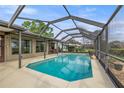 Screened-in pool with ample seating and a clear view of the lush backyard, perfect for outdoor relaxation at 6352 Huntington Dr, Zephyrhills, FL 33542