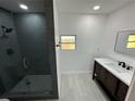 Updated bathroom featuring dark wood vanity, modern shower with glass door, and tile flooring at 6982 79Th N Ave, Pinellas Park, FL 33781