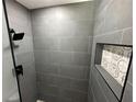 Contemporary shower with gray tile, a black shower head and mosaic tile decor at 6982 79Th N Ave, Pinellas Park, FL 33781