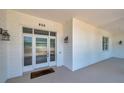 Inviting front entrance with a glass-paneled door and white siding, number 806, and sconce lighting at 806 Linwood Ter, Lutz, FL 33549