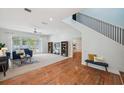Bright and airy living room with hardwood floors, a staircase, and access to the kitchen at 806 Linwood Ter, Lutz, FL 33549