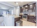 Well-lit kitchen features granite counters, stainless appliances, and easy access to living spaces at 9205 English Oaks Ln, Riverview, FL 33578