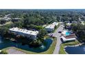 Aerial view of Heather Lake Condominiums featuring a lake, pool, and lush landscaping at 940 Virginia St # 304, Dunedin, FL 34698