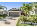 Single-Gathering home boasts a spacious garage, well-maintained lawn, and mature palm trees at 11426 Sage Canyon Dr, Riverview, FL 33578