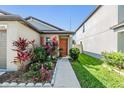 Charming single-Gathering home featuring a landscaped front yard with mature shrubs and colorful plants at 11426 Sage Canyon Dr, Riverview, FL 33578