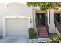 Home featuring an attached garage, brick stairs leading to the front door with decorative wreath, and manicured bushes at 1105 Venetian Harbor Ne Dr, St Petersburg, FL 33702