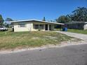 Cozy home featuring a neat front yard with a shaded carport, perfect for easy parking at 125 18Th Nw St, Ruskin, FL 33570
