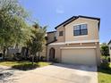 Charming two-story home with a two-car garage, lush landscaping, and a well-manicured lawn at 12717 Lemon Pepper Dr, Riverview, FL 33578
