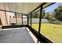 Enclosed screened patio with a concrete floor that overlooks a well-maintained lawn and features black metal framing at 12717 Lemon Pepper Dr, Riverview, FL 33578