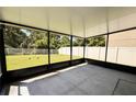 Enclosed screened patio with a concrete floor that overlooks a well-maintained lawn and features black metal framing at 12717 Lemon Pepper Dr, Riverview, FL 33578