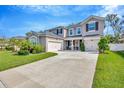 Charming two-story home featuring a three-car garage, well-manicured lawn, and a beautifully landscaped front yard at 12965 Satin Lily Dr, Riverview, FL 33579