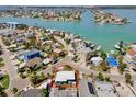 Aerial view of charming waterfront community, showcasing the home's proximity to the bay and neighborhood amenities at 13098 Boca Ciega Ave, Madeira Beach, FL 33708