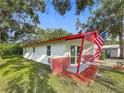 A single-story home with red brick accents, a red roof, well-maintained landscaping and a manicured lawn at 1444 Oak Haven Dr, Safety Harbor, FL 34695