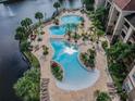 Stunning aerial view of the community pools surrounded by lush tropical landscaping and palm trees at 1610 Raena Dr # 204, Odessa, FL 33556