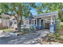 A quaint blue bungalow-style home, featuring a covered carport and well-kept yard at 2920 N 11Th St, Tampa, FL 33605