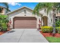 Inviting home featuring well-maintained landscaping, a two-car garage, and an arched entryway for added character at 29219 Perilli Pl, Wesley Chapel, FL 33543