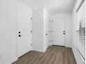 Bright entryway featuring light wood flooring, several doors, and a window with blinds for natural light at 29587 Fedora Cir, Brooksville, FL 34602