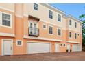 Charming peach-colored townhome with balcony, two car garage and paver driveway at 3025 W Grovewood Ct # B, Tampa, FL 33629