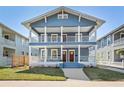 Charming blue two-story home featuring double porches, white columns, and lush green lawn at 307 S Newport Ave, Tampa, FL 33606
