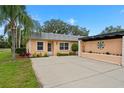 Charming home with lush landscaping and concrete driveway and peach-colored exterior at 3827 Trophy Blvd # 0, New Port Richey, FL 34655